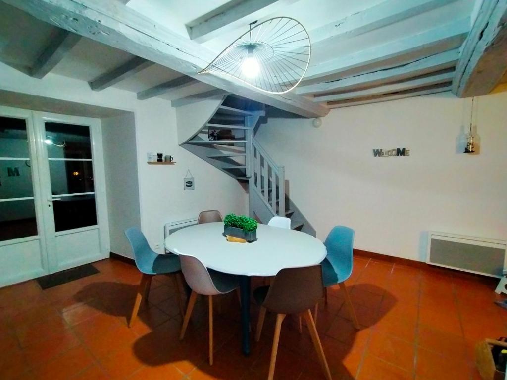 a dining room with a white table and chairs at Gîte Eloquent in Gratot