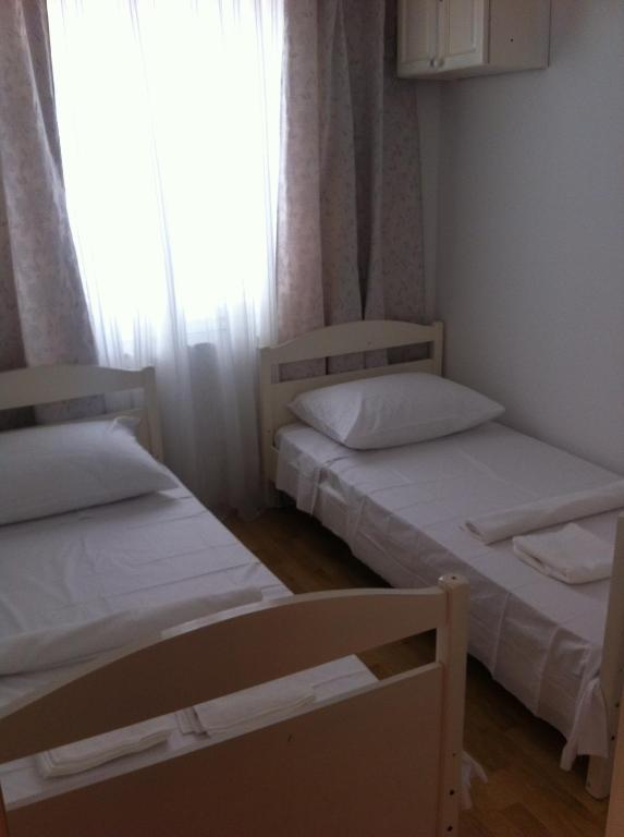 two beds in a small room with a window at Apartment Žarko in Brna