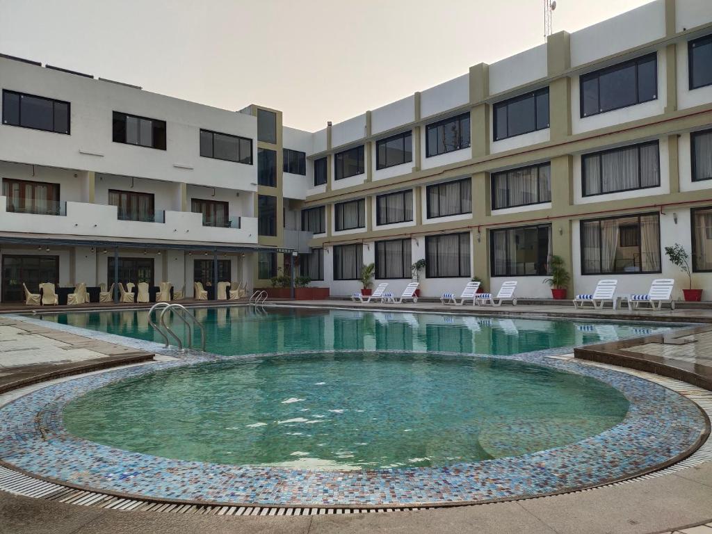 a swimming pool in front of a building at Inspira Resort & Spa in Silvassa