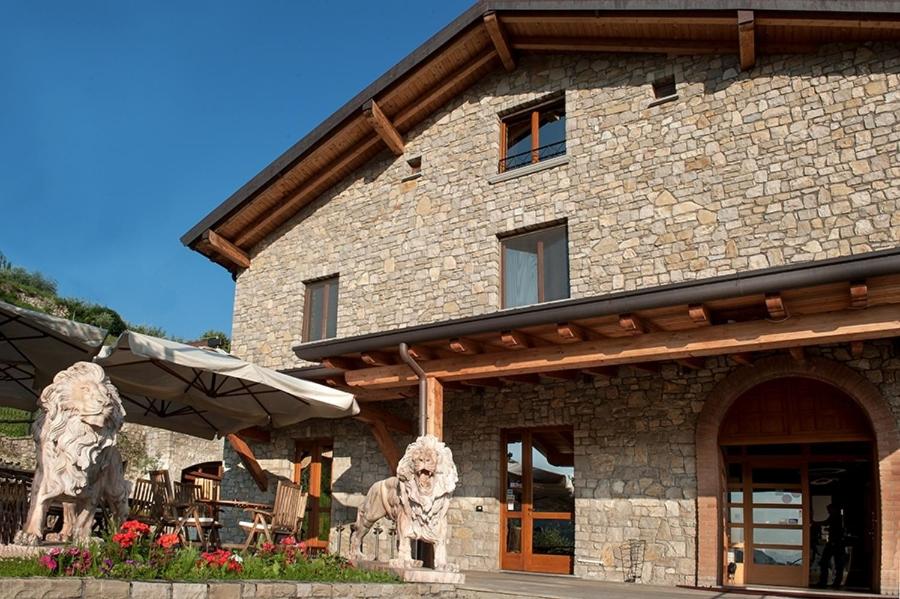 un edificio de piedra con una estatua delante de él en Hotel Fontana Santa, en Grumello del Monte