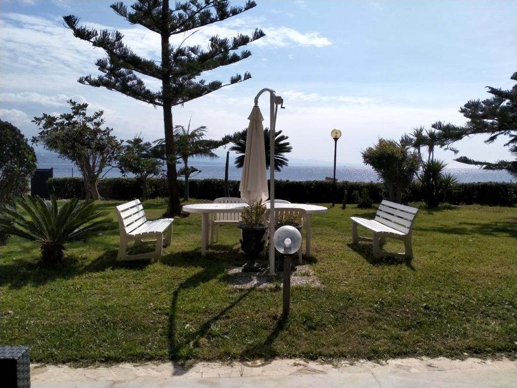 a park with two benches and a fire hydrant at Villa sullo stretto in SantʼAgata