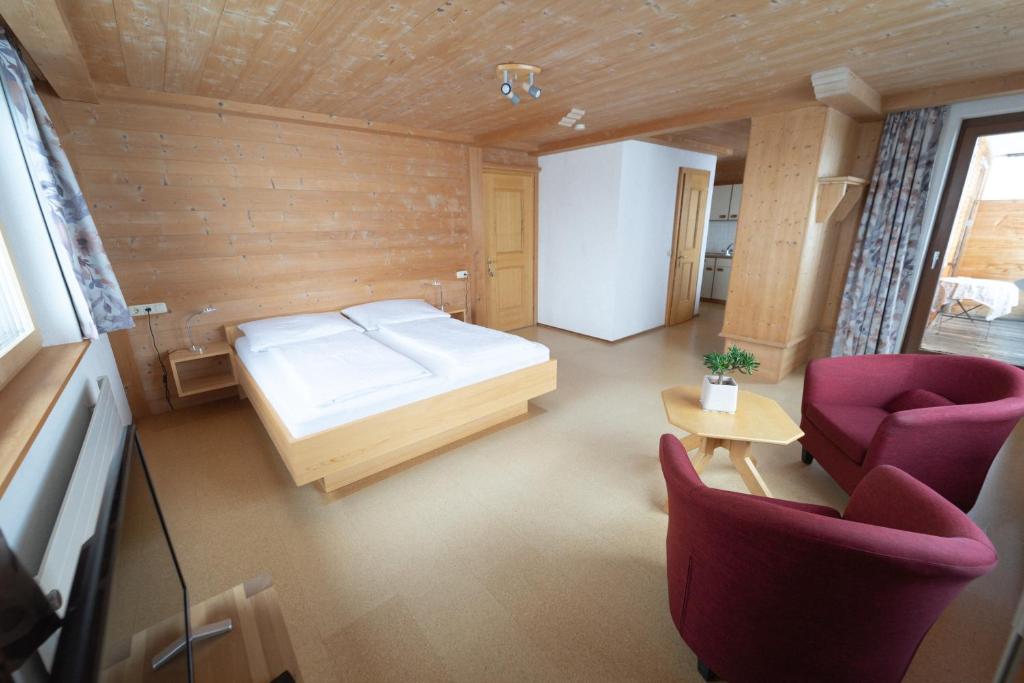 1 dormitorio con 1 cama, 2 sillas y mesa en Ferienwohnung Petra Natter en Bezau