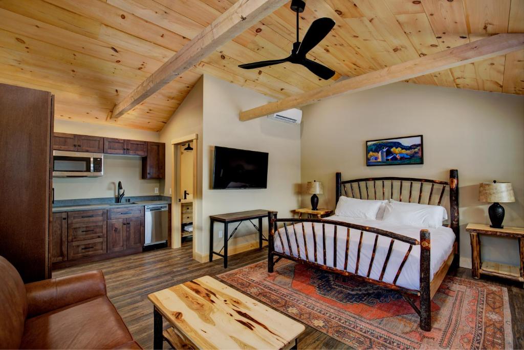 a bedroom with a bed and a living room at The Lodge by Sunapee Stays in Sunapee