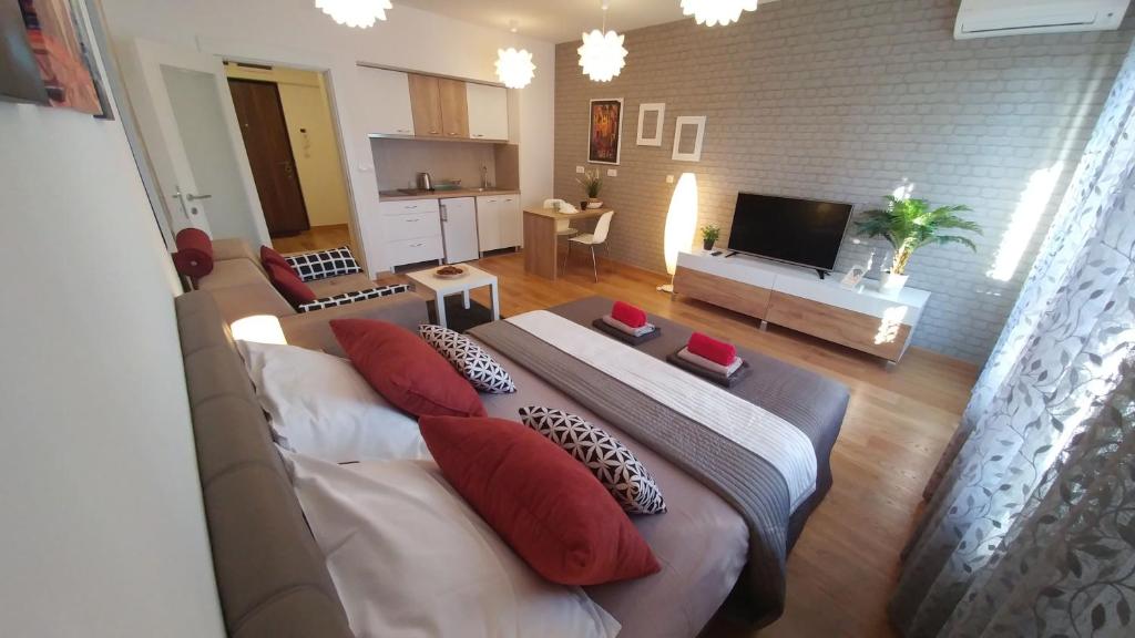Apartments Delta A Blok - Savada في بلغراد: غرفة معيشة بها أريكة وتلفزيون