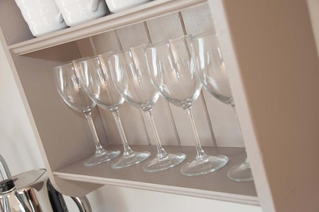 a row of wine glasses sitting on a shelf at One Abbey Lane in Southam