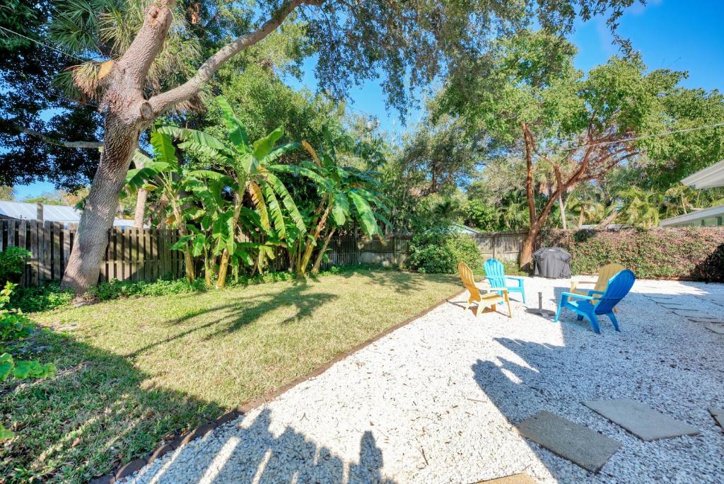 a backyard with a table and chairs and a tree at House of the Sun in Siesta Key