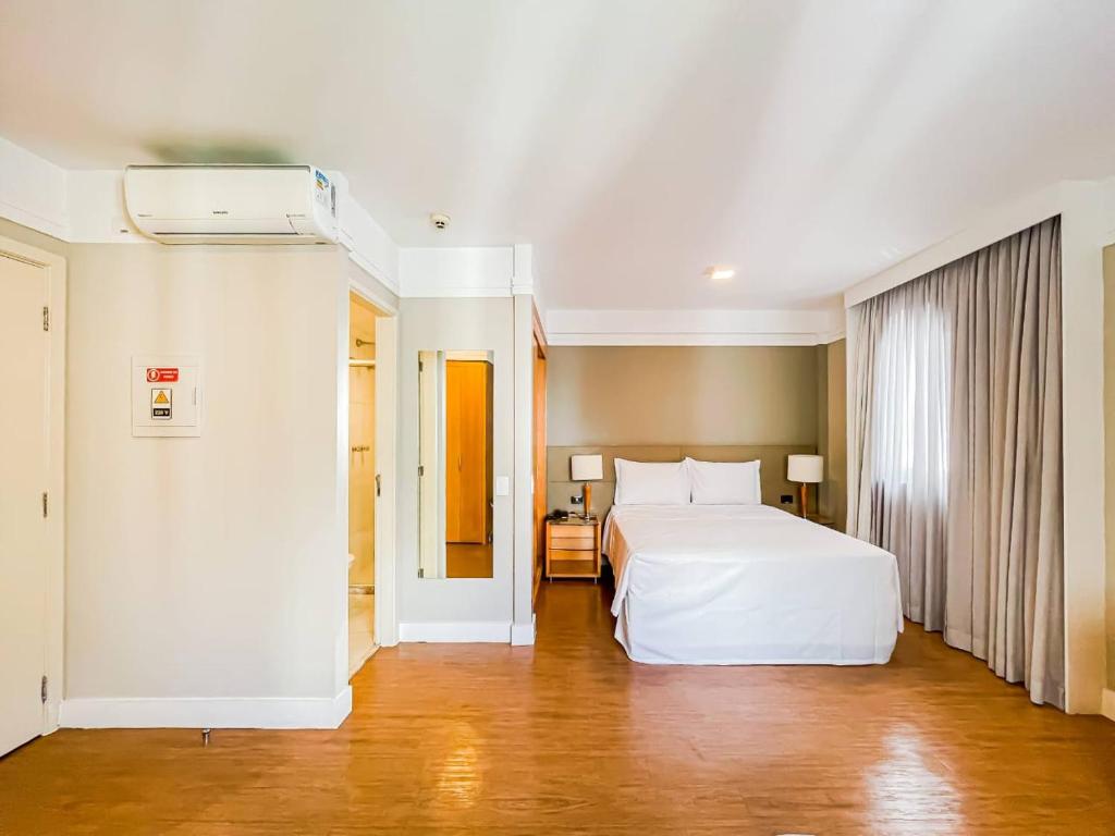 sypialnia z dużym białym łóżkiem w pokoju w obiekcie Flat Hotel Transamérica - Rua Bela Cintra w São Paulo