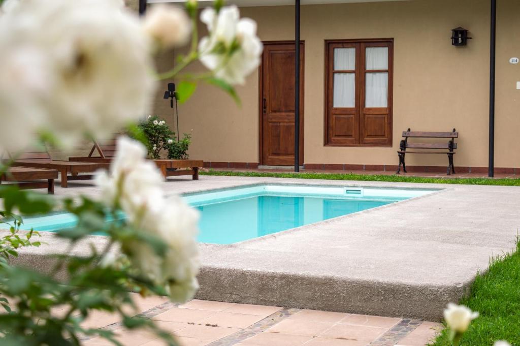 a swimming pool with a bench and flowers at El Arribo Hotel in San Salvador de Jujuy