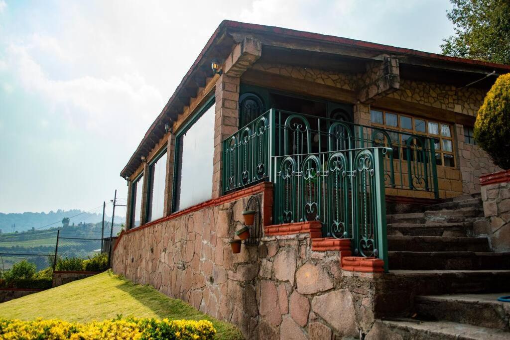 une maison avec une porte verte sur un mur en pierre dans l'établissement Casa de Piedra, 
