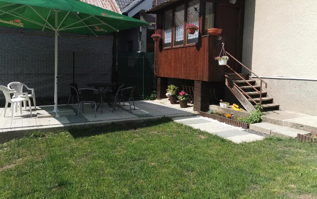 a house with a patio with chairs and an umbrella at Privat Teo Podtureň in Liptovský Mikuláš