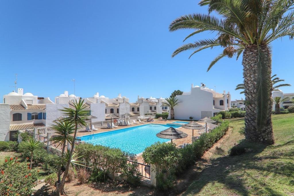 een villa met zwembad en palmbomen bij Vila Mourisca in Porches