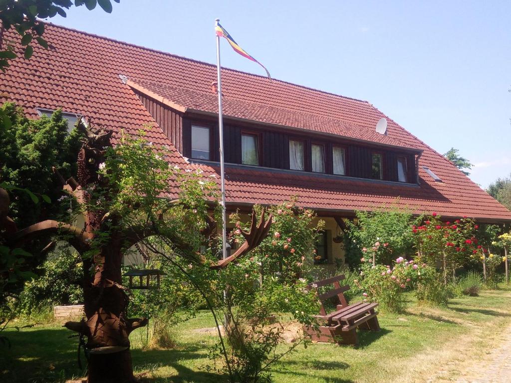 a house with a red roof and a tree at Five Oaks - Rote Wohnung in Hohenkirchen