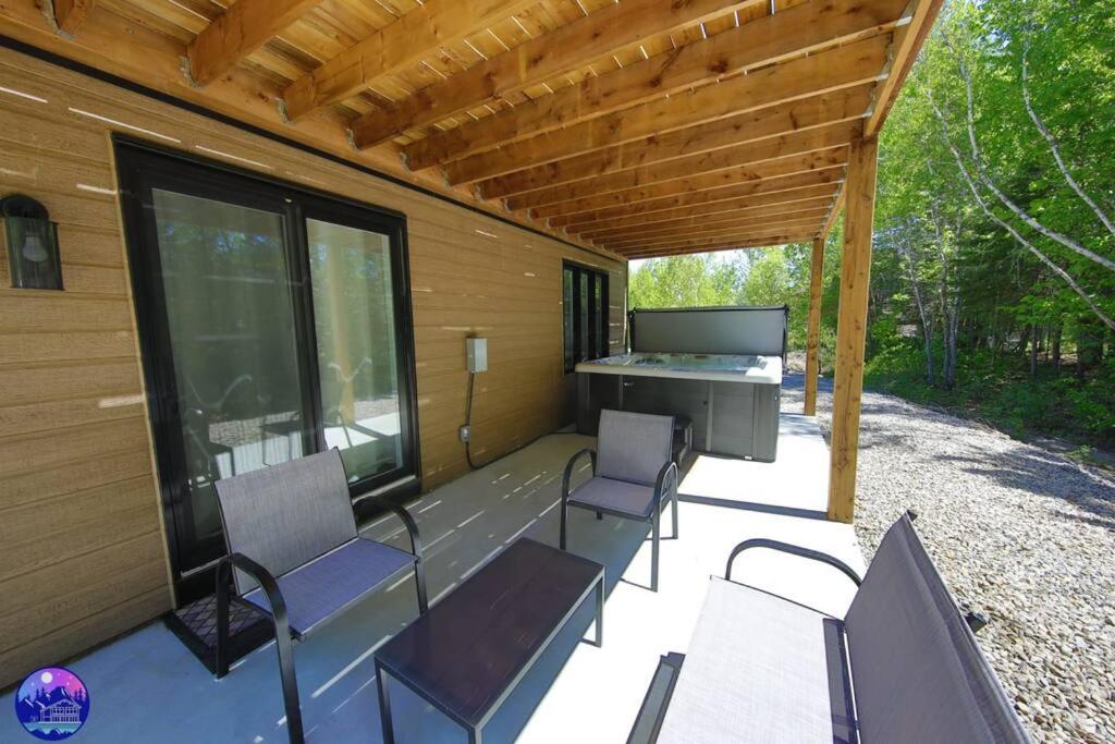 a screened in porch with chairs and a grill at Chalet le Caribou- Chalets Galaxia in Saint-Alphonse-Rodriguez