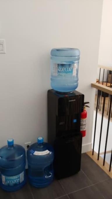 two water containers are sitting on top of a water cooler at Chalet le Caribou- Chalets Galaxia in Saint-Alphonse-Rodriguez