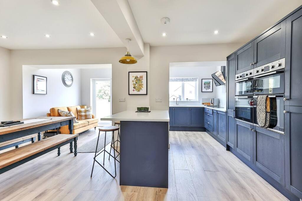 une grande cuisine avec des placards bleus et un comptoir dans l'établissement Elegant Retreat Nook at Peak District Gateway, à Totley