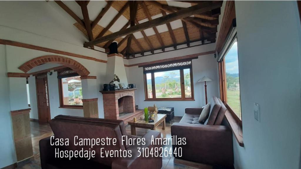een woonkamer met een bank en een open haard bij Casa Campestre Flores Amarillas in Villa de Leyva