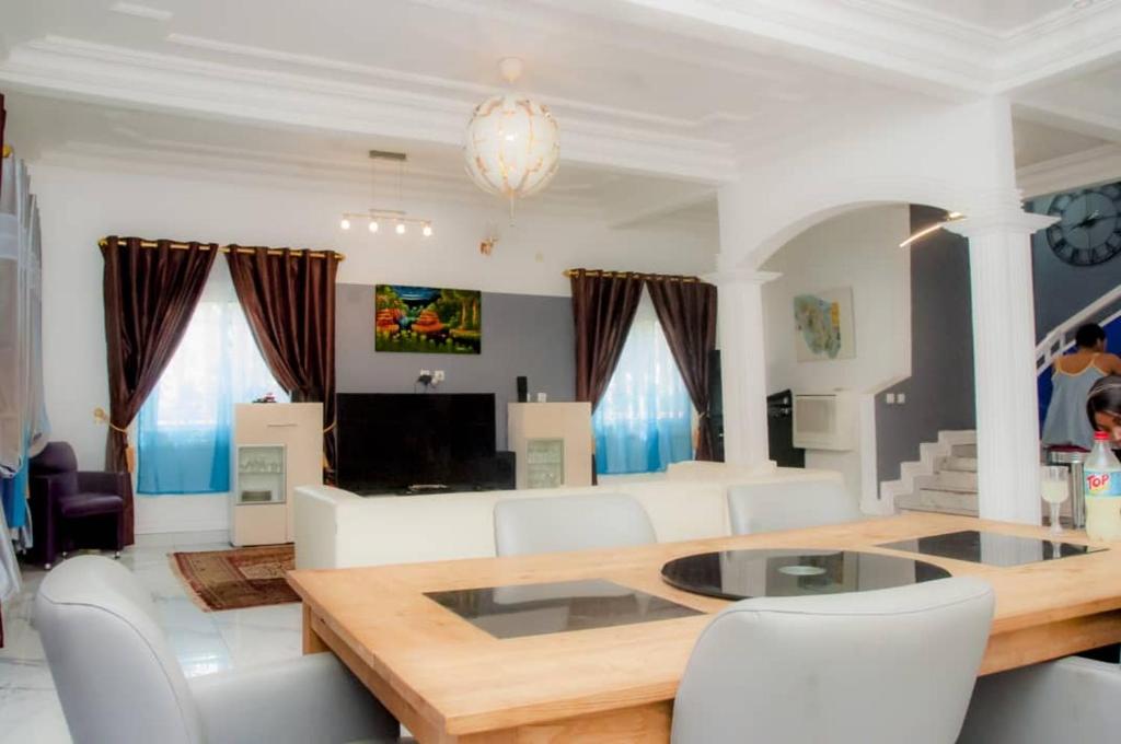 sala de estar con mesa y sillas blancas en Villa luxueuse - Odza - Yaoundé, en Yaoundé
