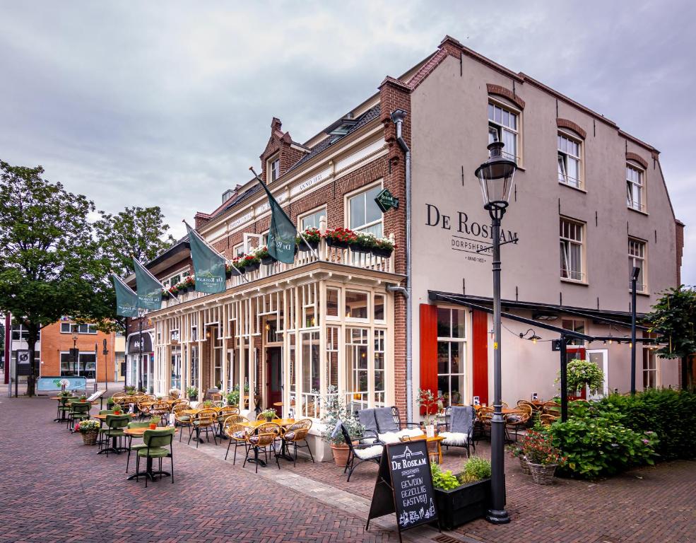 een straat met tafels en stoelen voor een gebouw bij Dorpsherberg De Roskam in Nunspeet