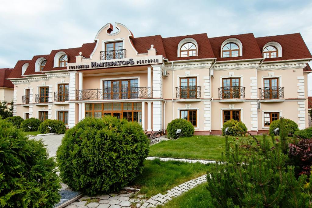 duży biały budynek z brązowym dachem w obiekcie Imperator Hotel w mieście Tuła