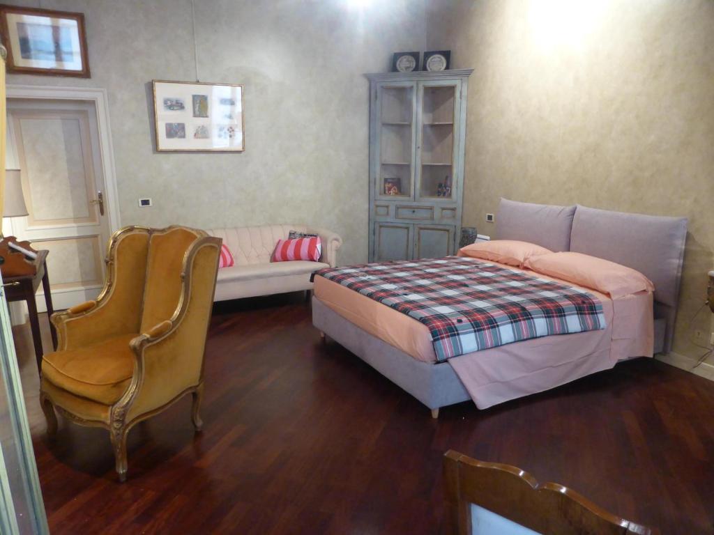- une chambre avec un lit et une chaise dans l'établissement Galleria d'Arte - Foresteria, à Brescia