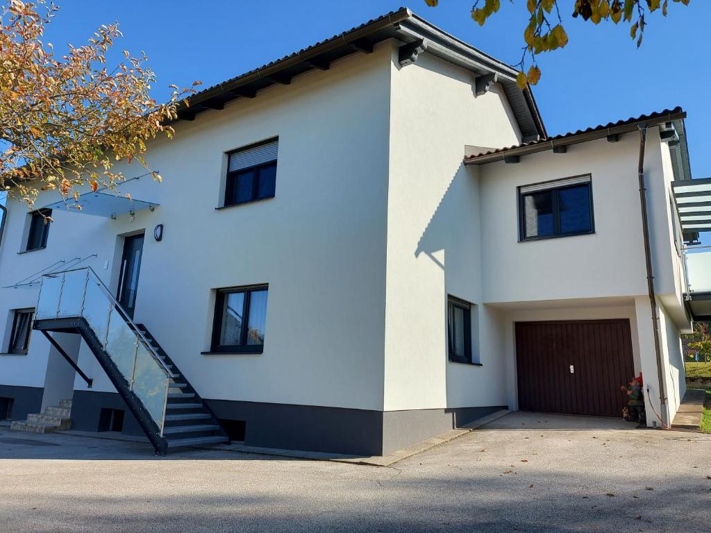 een wit huis met een trap ervoor bij Appartement Lindenheim in Sankt Kanzian