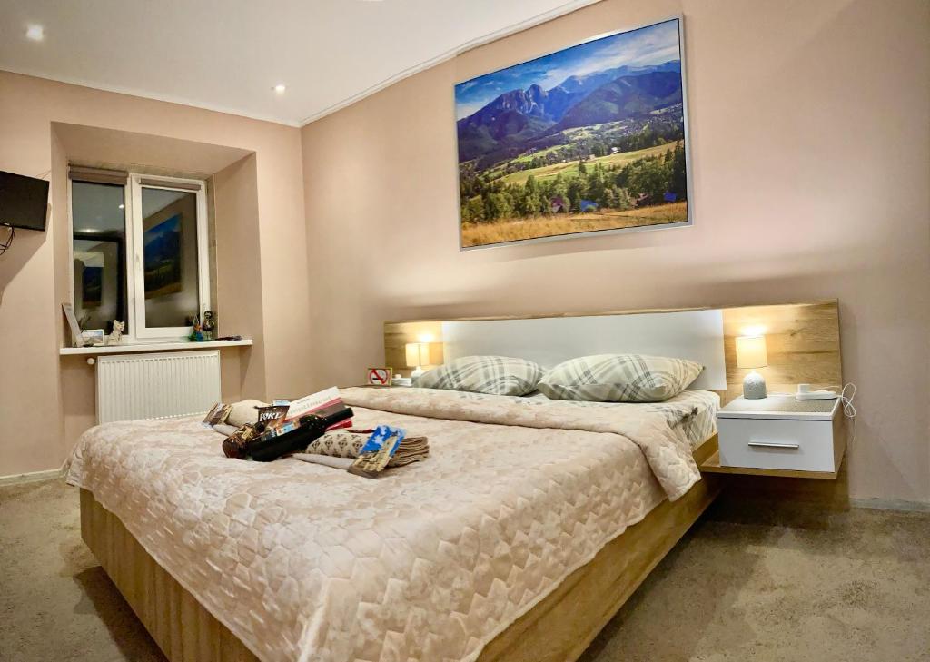 ein Schlafzimmer mit einem großen Bett und einem Gemälde an der Wand in der Unterkunft Francis Apartment in Lwiw
