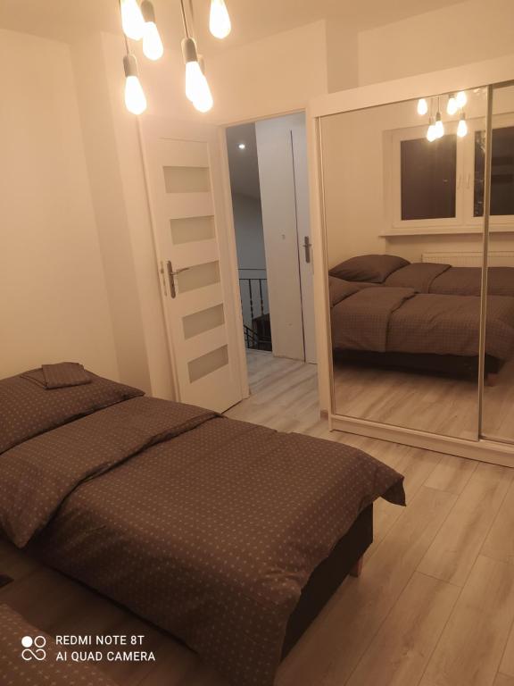 a bedroom with a bed and a mirror at Apartament Brzechwy in Poznań