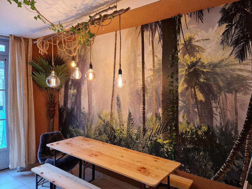 una mesa en una habitación con plantas en la pared en Le Lude Land Lodge en Le Lude