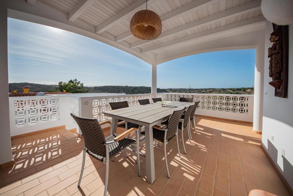 een patio met een tafel en stoelen op een balkon bij Casa da costa in Carrapateira