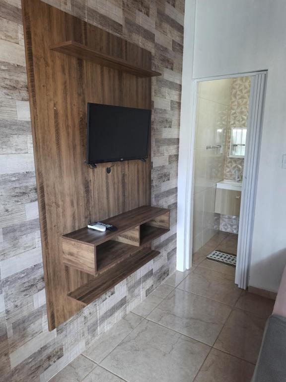 a living room with a television on a wall at Moradas Jeane in Guarda do Embaú