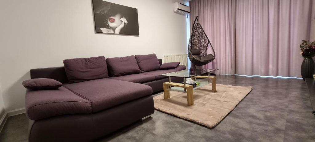 ママイア・ノルドにあるAndrew Beach Apartmentの紫色のソファとテーブル付きのリビングルーム
