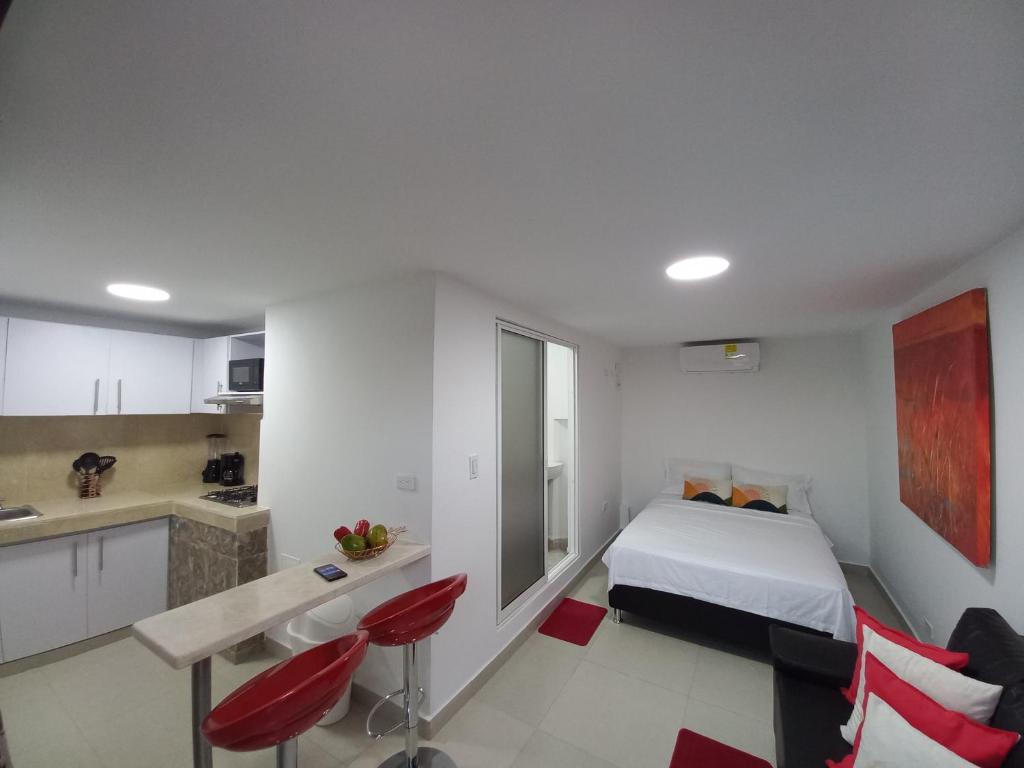 um quarto branco com uma cama e uma cozinha em La casita de max y tim apartaestudio 4to piso em Cartagena de Indias