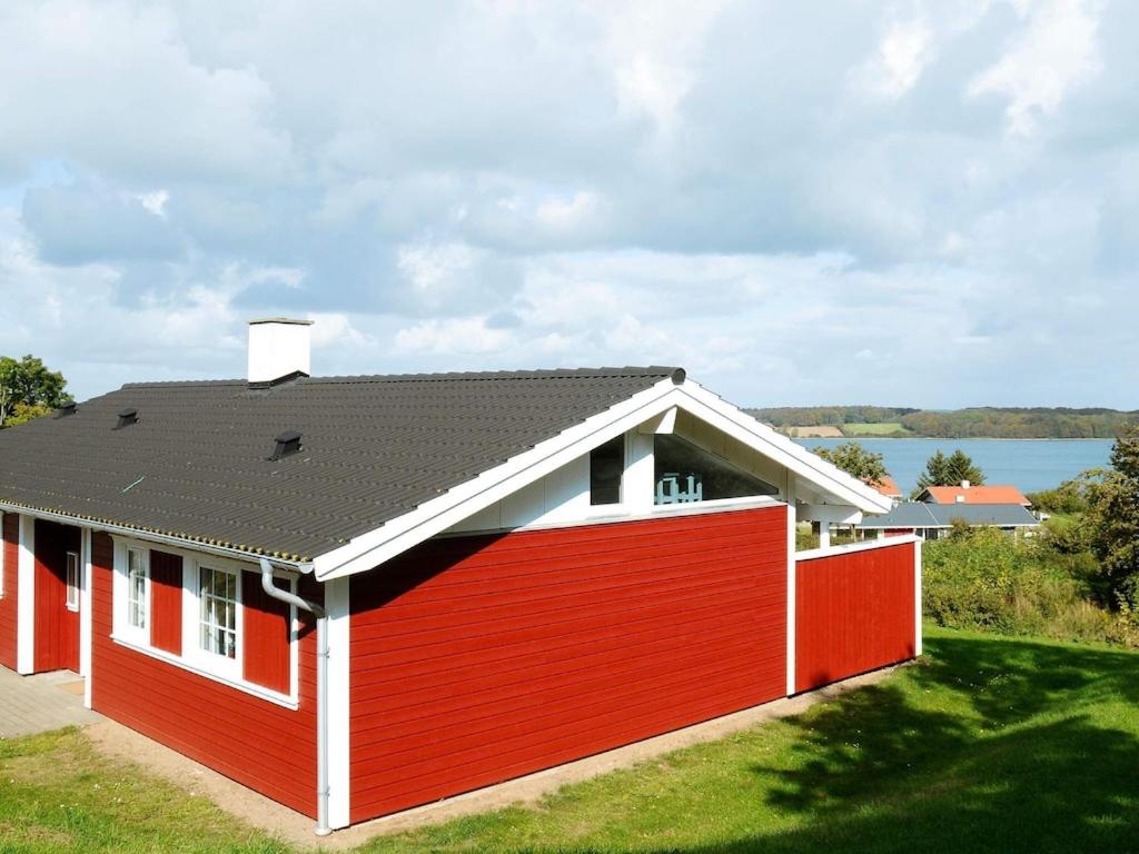 una casa roja y blanca con techo negro en 8 person holiday home in Aabenraa, en Løjt