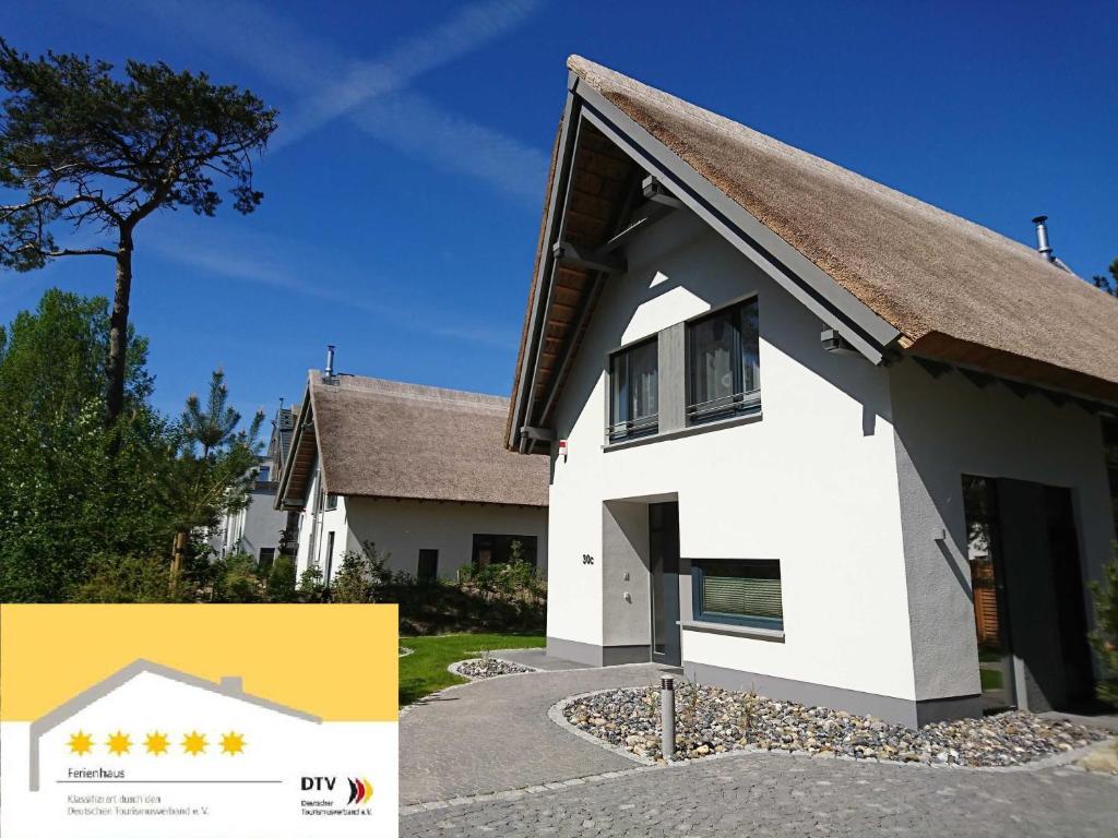 ein weißes Haus mit braunem Dach in der Unterkunft Straße der Freundschaft 30c in Ostseebad Karlshagen