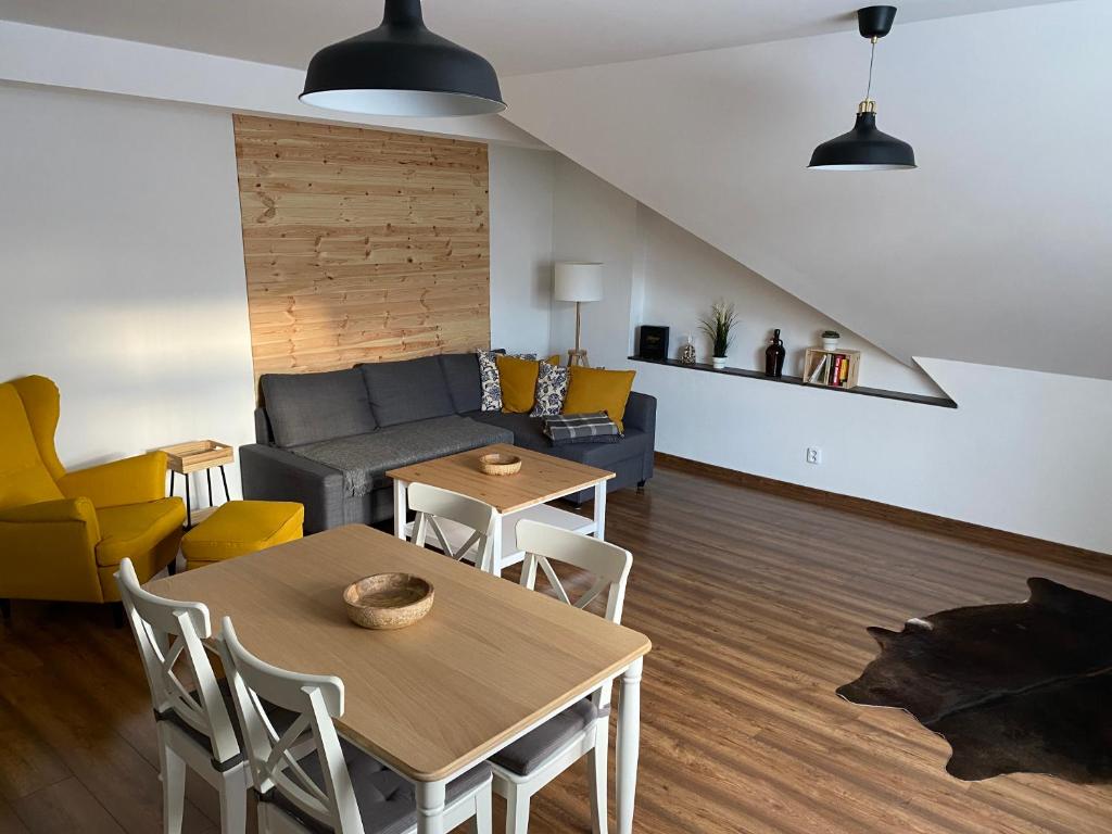 a living room with a couch and a table and chairs at Apartmán U Pátka in Rýmařov
