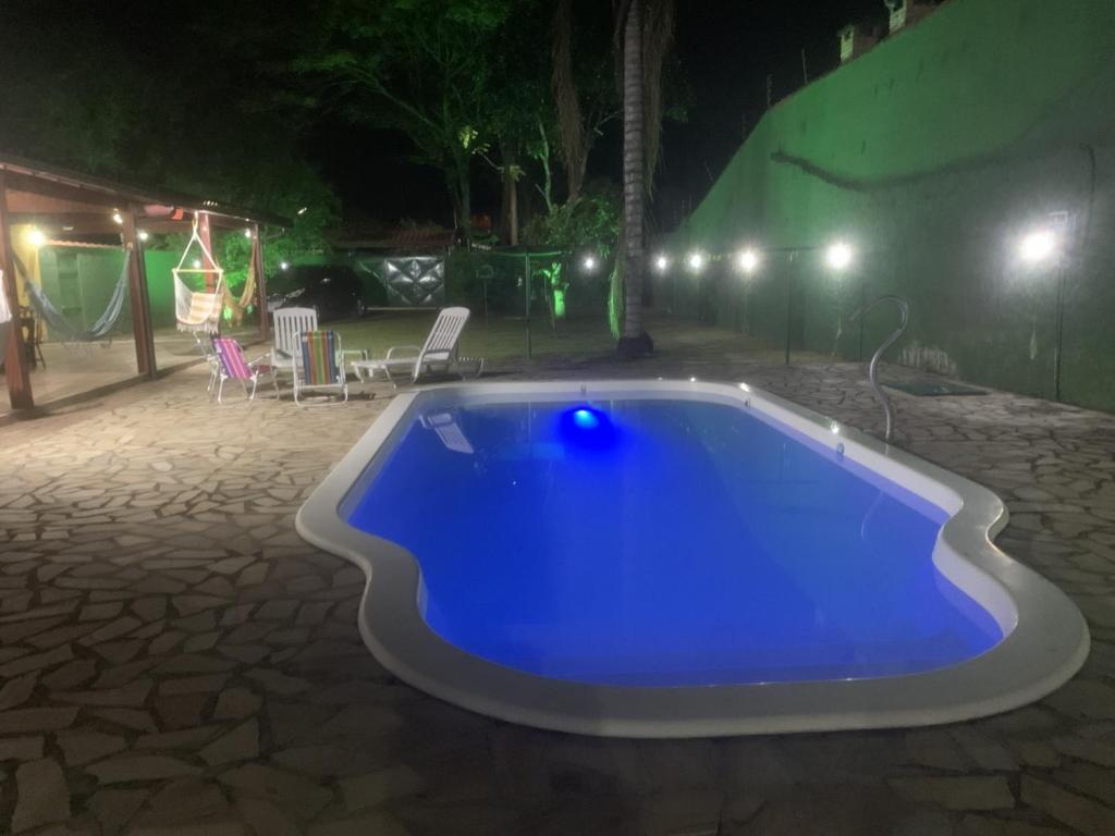 a blue swimming pool in a yard at night at Casa de Campo em Penedo - RJ in Itatiaia
