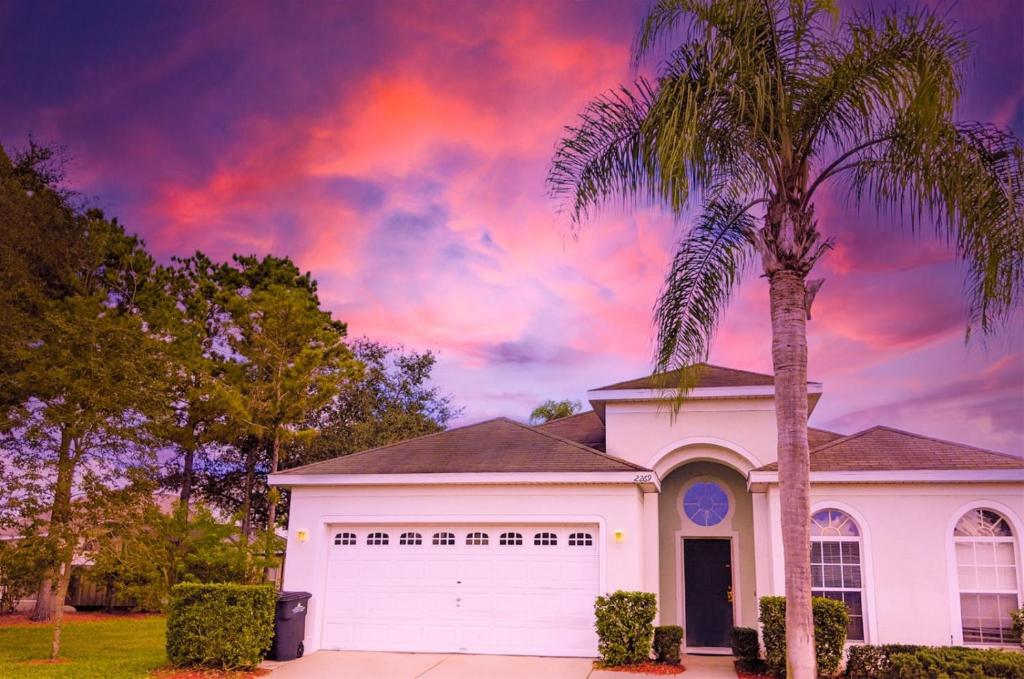 una palmera frente a una casa blanca en 4 Bed 2269, en Kissimmee