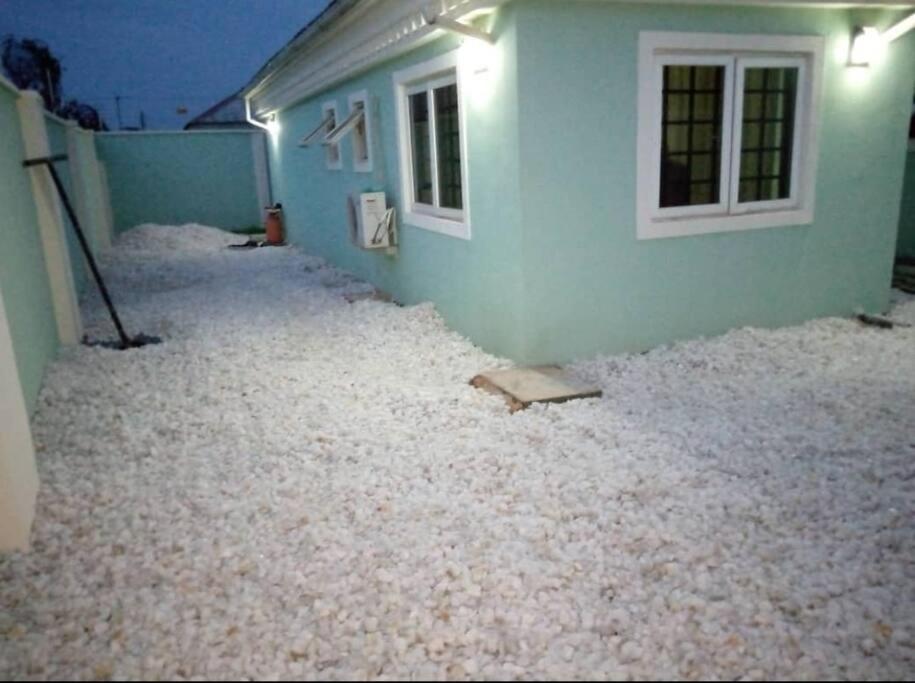 a house with a lot of white gravel around it at XrisBun Apt 1BR - Laderin GRA in Abeokuta