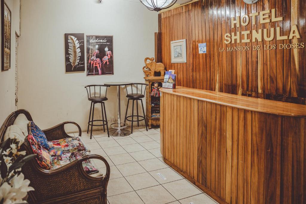 a hotel shibuya lobby with a bar and stools at Hotel Shinula in Huehuetenango