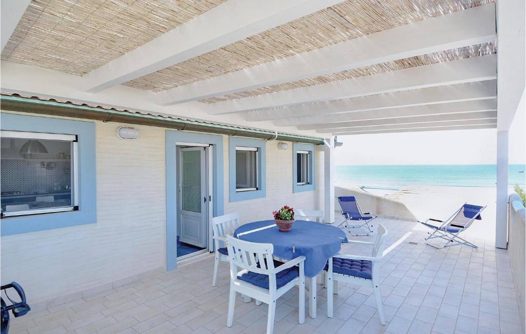 a patio with a table and chairs and the beach at Stunning Apartment In Punta Braccetto Rg With Kitchen in Punta Braccetto