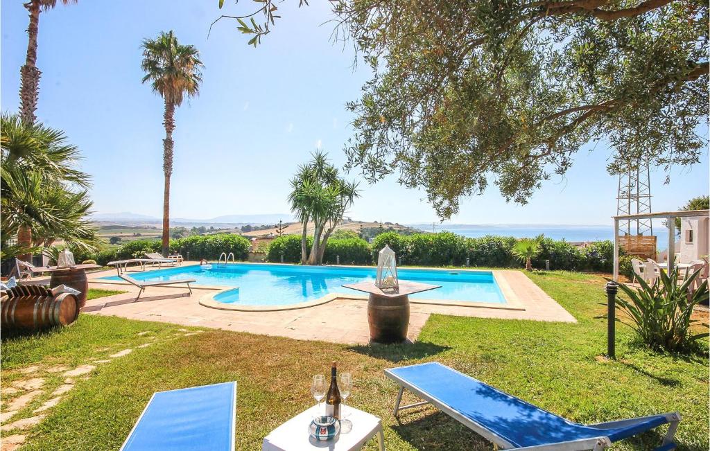 uma piscina com palmeiras e cadeiras num quintal em Villa Curreri em Porto Palo