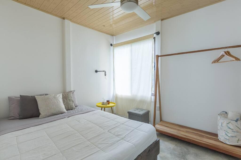 1 dormitorio con cama y ventana grande en Ambar House, en Santa Teresa Beach