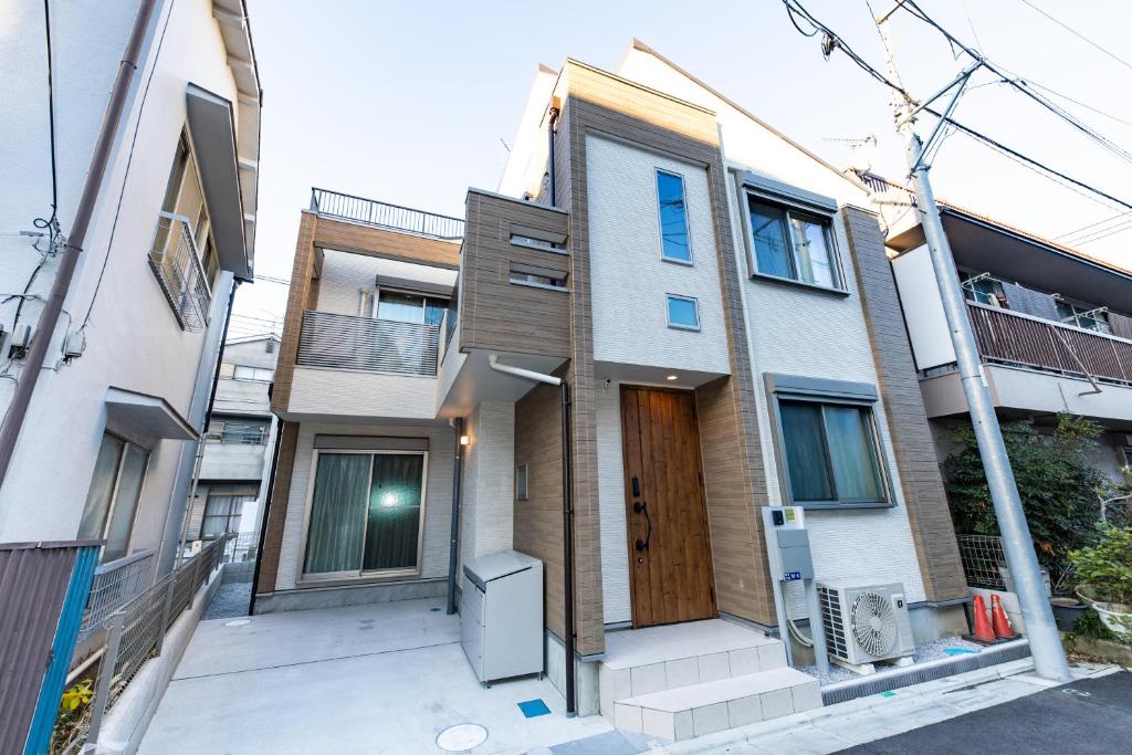 東京にあるY's HOTEL KAMEARIの通りに建つ木製のドア付きのアパートメントビル