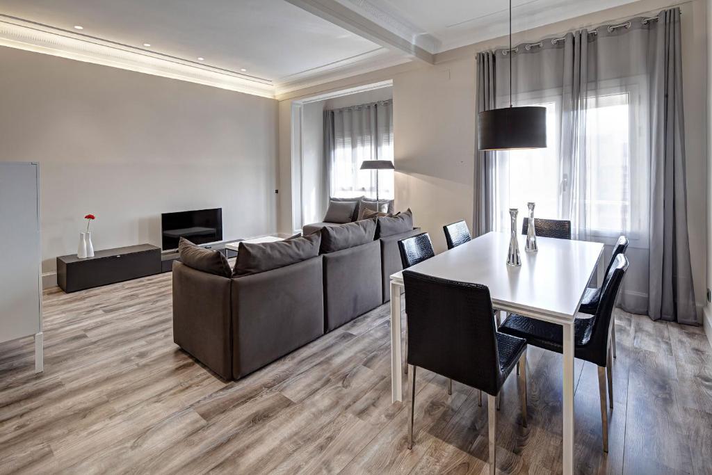 a living room with a couch and a table and chairs at Habitat Apartments Paseo de Gracia in Barcelona