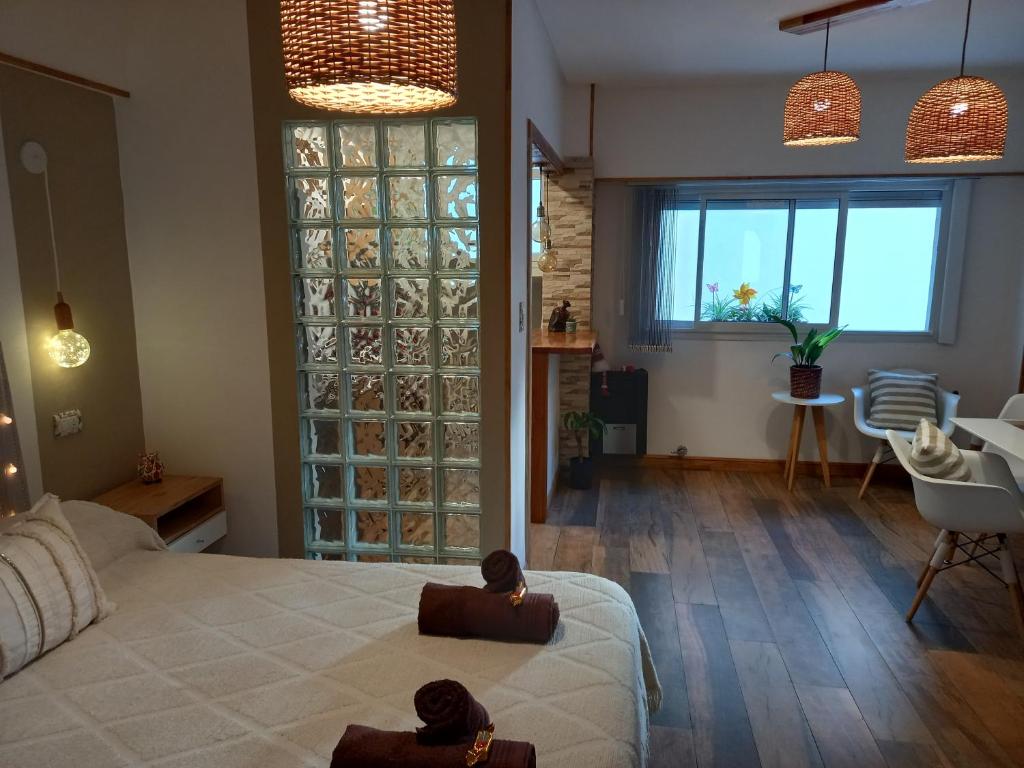 a bedroom with a large bed and a living room at DESCANSO IDEAL IV "el placer de los detalles" in Mar del Plata