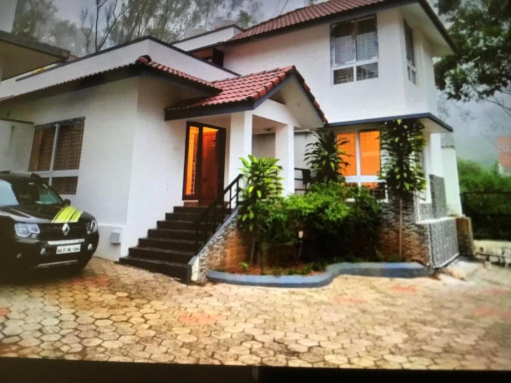 a house with a car parked in front of it at Misty Meadows in Yercaud