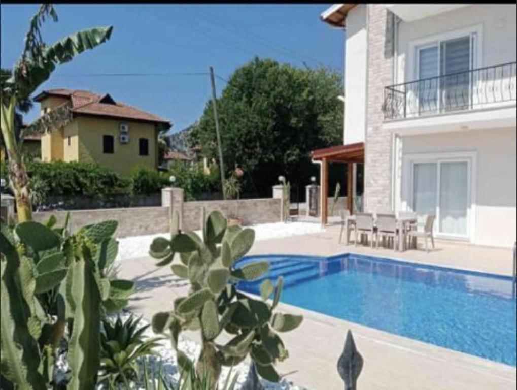 a villa with a swimming pool next to a house at Stylish Ground floor 3-Bed Apartment in Dalyan in Ortaca