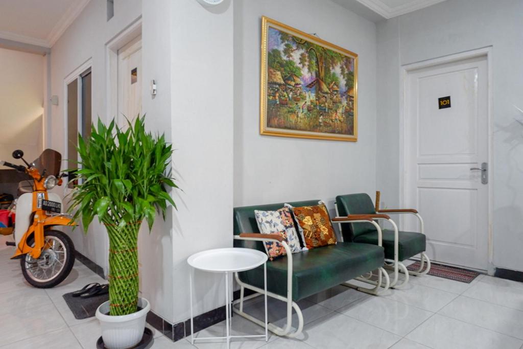 梭羅的住宿－RedDoorz near Jalan Adi Sucipto Solo，客厅配有绿色沙发和桌子