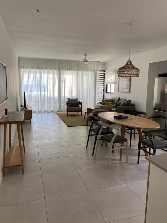 a large living room with a table and chairs at Eastern Blue Beachfront Luxury Apartment in Poste Lafayette