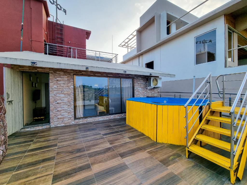 a balcony with a yellow and blue table on a building at Pooja Villa Suites-Rooms and Pool, Igatpuri in Igatpuri